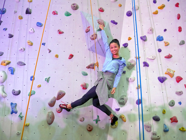 The model shows off just how comfortable those jeans are by rock climbing in them.