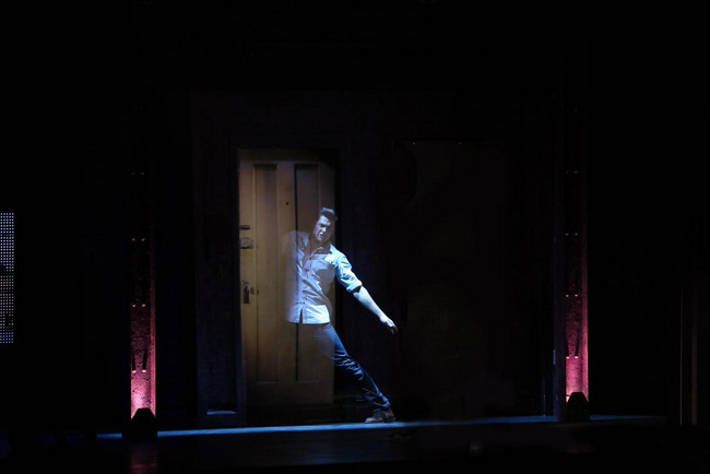 Liam Doyle walking through a door on stage. Credits: GWB Entertainment.