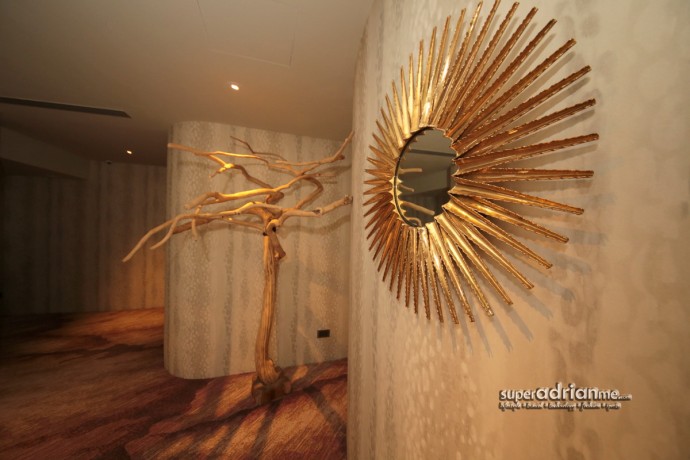 A leafless coffee tree installation and a "sun ray" mirror in earth colours at the Welcome Reception at The Knightsbridge Clinic