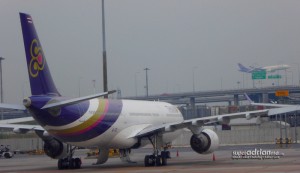 Thai Airways aircraft parked at Suvarnabhumi Airport in Bangkok while another takes off