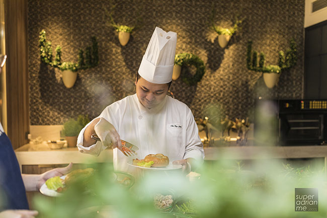 Chef from Hotel Jen Tanglin Singapore preparing a Chilli Crab Fondue dish for guests