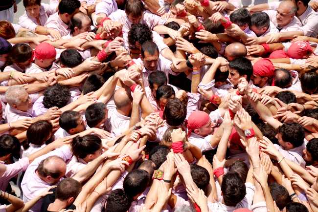 Building the base of the gravity-defying human towers, Castell, as demonstrated by the Catalonia community of the Kingdom of Spain.