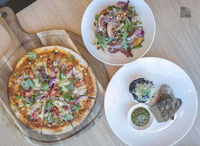 Flat Lay of Singapore Chilli Crab Pizza (S), Proscuitto & Belgian Endive Salad (S) and 🍅 🌿 🥑 🍄 Bruschetta (S) from Sky 22