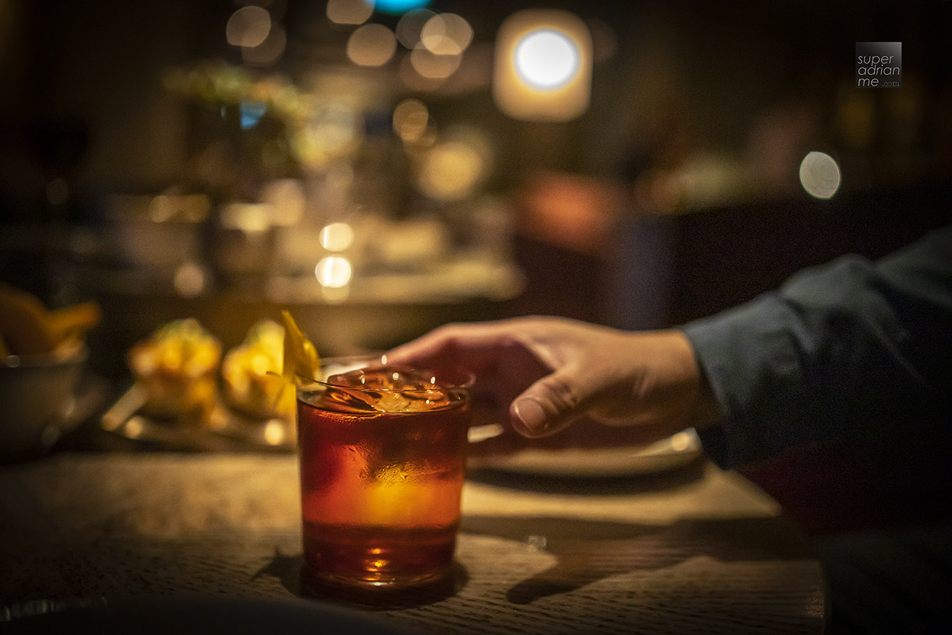 Reaching out for a classic Negroni at MO BAR in Mandarin Oriental, Singapore